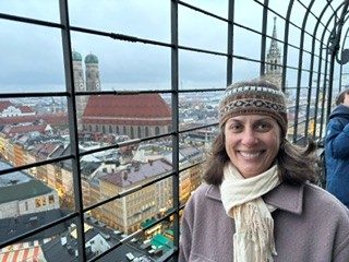 Ann Hatcher smiling on a rooftop overlooking Munich, Germany.