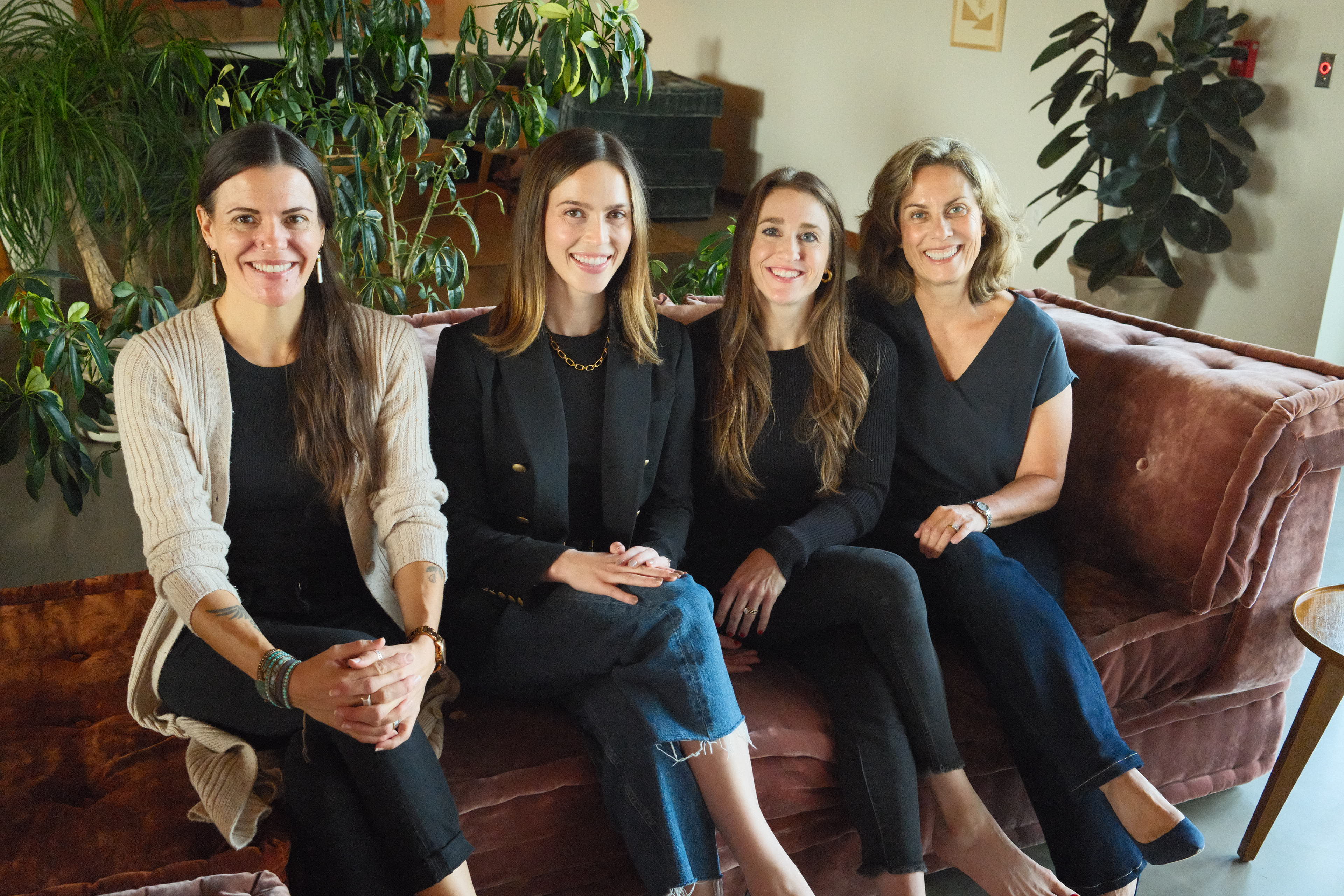 The Anomaly Therapy team seated together on a velvet couch in the office lounge.